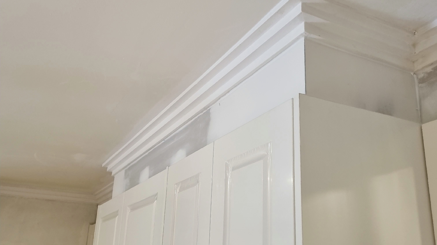 Cornice fitted where built-in cupboards meet the ceiling, joins set ready for paint